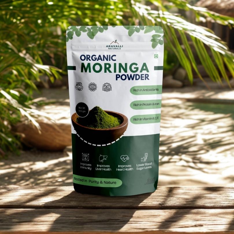 Package of organic moringa powder with greenery in the background